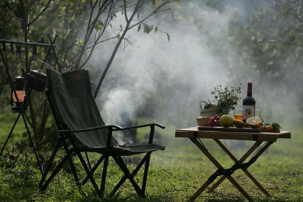 Camping chair and table with wine and fruits when someone is car camping